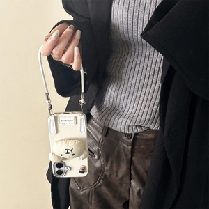 Detail of cream white phone case with plush cartoon dog and leather hand strap