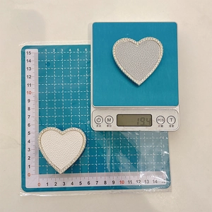 Detailed view of a 6cm heart-shaped phone grip showing 19.4g weight on digital scale