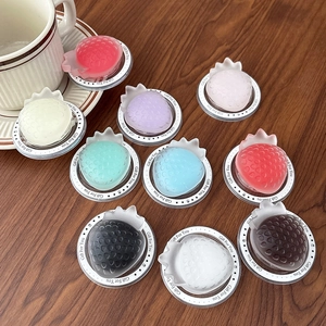 Magnetic strawberry phone grip stands in 10 assorted colors on a wooden surface