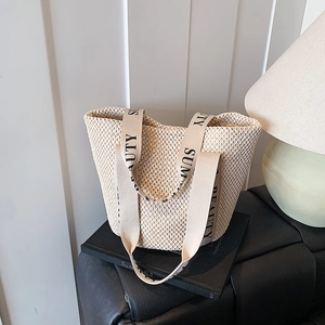 Cream woven straw tote bag with Summer Beauty straps shown on a black stool