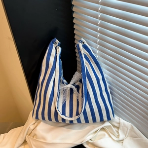 Modische blau-weiß gestreifte Canvas-Tasche mit weißer Spitzenschleife und Riemen
