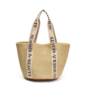Light beige straw tote bag with Summer & Beauty woven handles and brown base for vacation