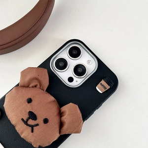 Detail of 3D plush bear and coffee cup charm on black leather texture phone case