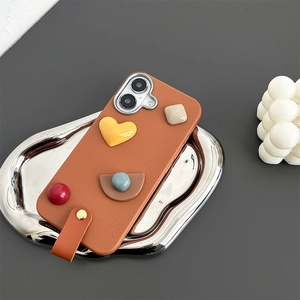 Detail of brown leather phone case with 3D geometric heart charms and wrist strap handle