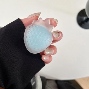 Detail view of a strawberry shaped phone grip with a semi-transparent blue and pink finish