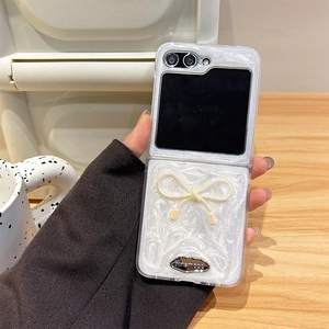 Chic pearlescent white Samsung Z Flip6 case with yellow bow and marble pattern texture