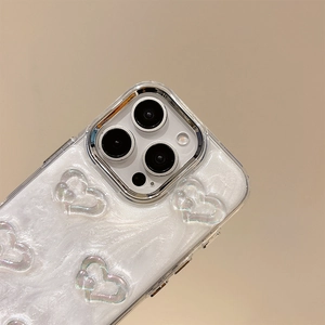 Dettaglio del decoro a cuore 3D e protezione fotocamera su custodia texture perlata