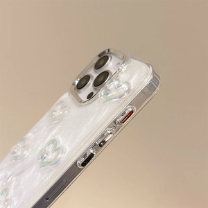 Dettaglio macro della cover iPhone perlata con cuore 3D e pulsanti laterali