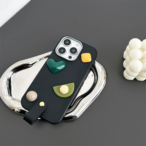 Detail view of black leather phone case with 3D geometric shapes and leather hand strap