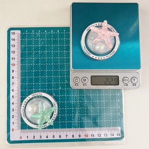 Starfish glitter phone grip in pink and green shown with 5cm size and 22.9g weight scale