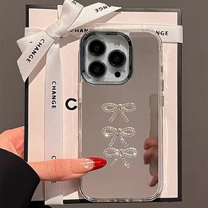 Detail of mirror iPhone case featuring rhinestone bows and a stylish carrying chain