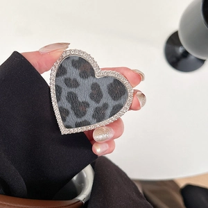 Détail du support téléphone cœur avec imprimé léopard gris et bordure en strass