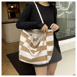 Detail of striped canvas tote bag showing weave texture and dual shoulder straps