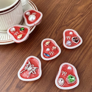 Red heart phone grip set with rhinestones and pearls on a warm wooden background