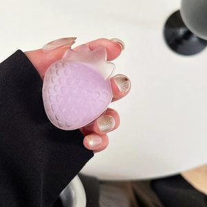 Close-up of translucent purple strawberry phone grip on a hand with matte finish details