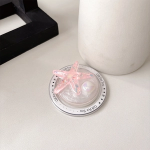 Macro detail of pink starfish phone grip with glitter resin and pearl embellishment