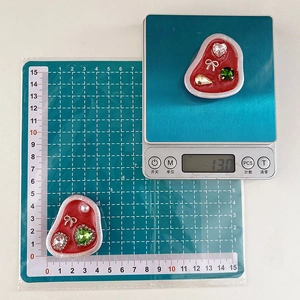 Detailed view of red resin heart phone grips with inlaid rhinestones on a scale
