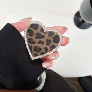 Gros plan d'un support de téléphone en cœur avec motif léopard et strass brillants