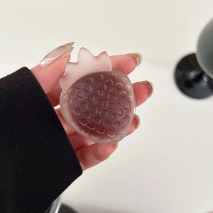 Macro detail of the semi-transparent pink strawberry resin phone grip with matte finish texture