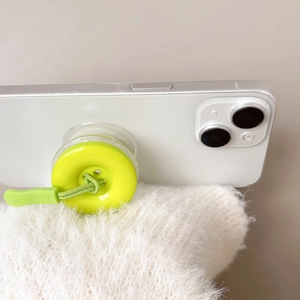 Dettaglio del supporto per telefono a bottone verde neon con cordoncino intrecciato