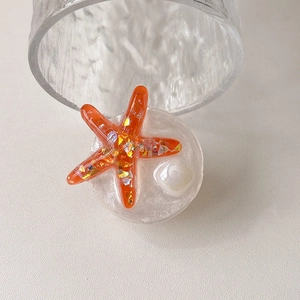 Detail of glitter starfish phone grip with iridescent sequins and white pearl decor