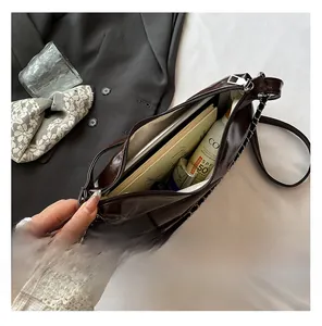 Detailed interior of a dark brown glossy leather bag showing large storage capacity