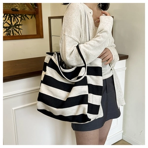 Detail of black and white striped canvas tote bag with thick strap and spacious design