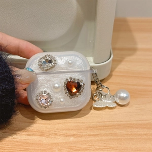Detail of glitter heart case for AirPods with pearls and a metal butterfly charm