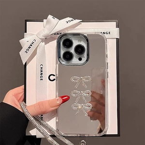 Close-up of mirror phone case with rhinestone bows and luxury chain in gift box
