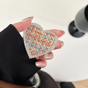 Détail du support de téléphone en forme de cœur avec tweed orange et strass brillants