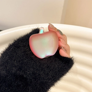 Macro shot of an apple-shaped iridescent phone grip with gradient purple-pink finish