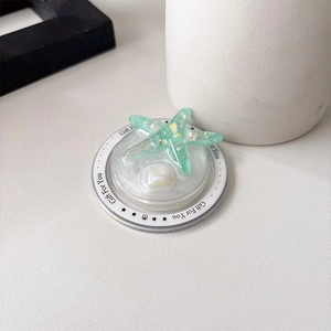 Macro detail of mint green resin starfish phone grip with laser sequins and glitter finish