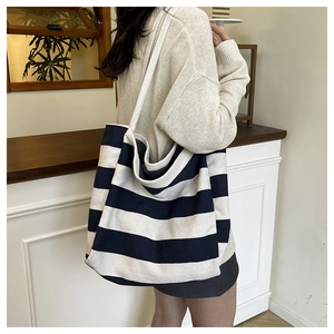 Close-up of a large canvas tote bag featuring navy blue and white horizontal stripes