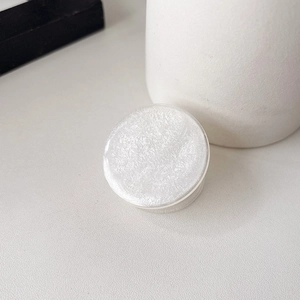 Detail of white glitter round phone socket holder with translucent base on a minimal desk