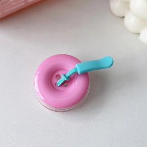 Dettaglio del supporto per telefono a bottone 3D rosa con cordino intrecciato blu