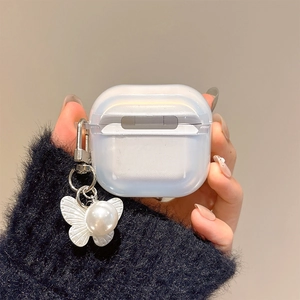 Detail of translucent frosted AirPods case with white butterfly and pearl keychain charm
