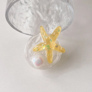 Detail of yellow glitter resin starfish phone grip with pearls and green sequins