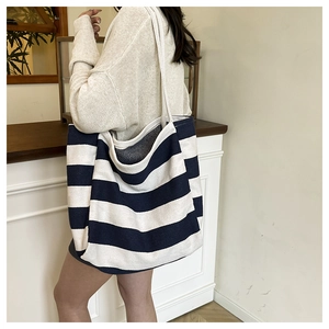 Close-up of durable navy blue and white striped canvas material and wide shoulder strap