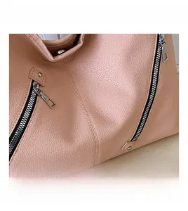 Detailed macro view of pink lychee textured faux leather underarm bag with metal zipper