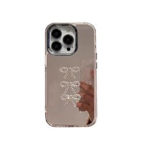 Mirror iPhone case featuring three sparkling rhinestone bows and a clear protective bumper