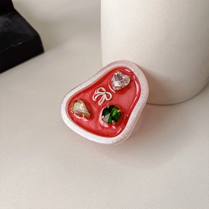 Detail of red heart phone grip with pearl finish, colorful gemstones and silver bow