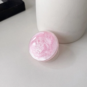 Macro detail of round pink glitter phone grip stand with a sparkling pearlescent texture