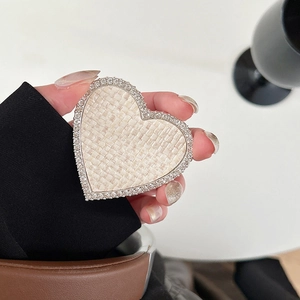 Vue détaillée du support de téléphone en forme de cœur avec tissu beige et strass brillants