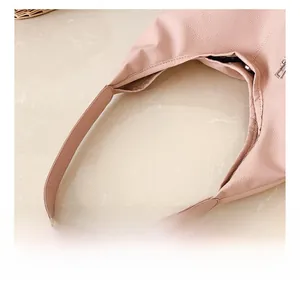 Detail of the pink litchi grain leather texture and comfortable top handle of the tote bag