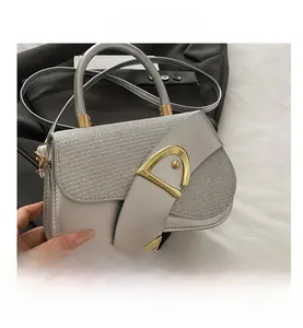 Detail of silver saddle bag showing textured glitter panels and golden D-shaped buckle