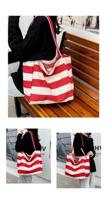Detail of red and white striped canvas tote bag with thick red fabric shoulder straps