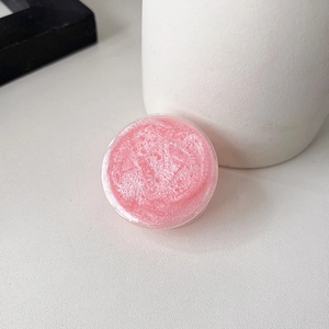Macro shot of pink glitter phone grip stand with shimmering details and minimalist round design