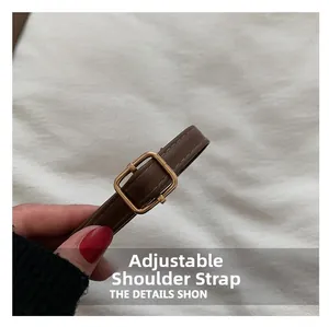Détail de la bandoulière réglable en cuir marron avec boucle en métal doré