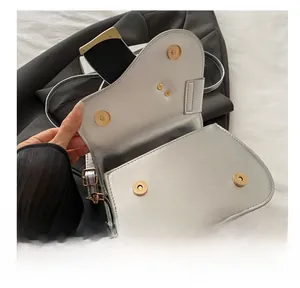 Detail view of the silver saddle bag featuring a functional magnetic metal closure