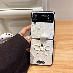 Détail de la coque en cuir plissé crème avec nœud à pois pour Samsung Z Flip6